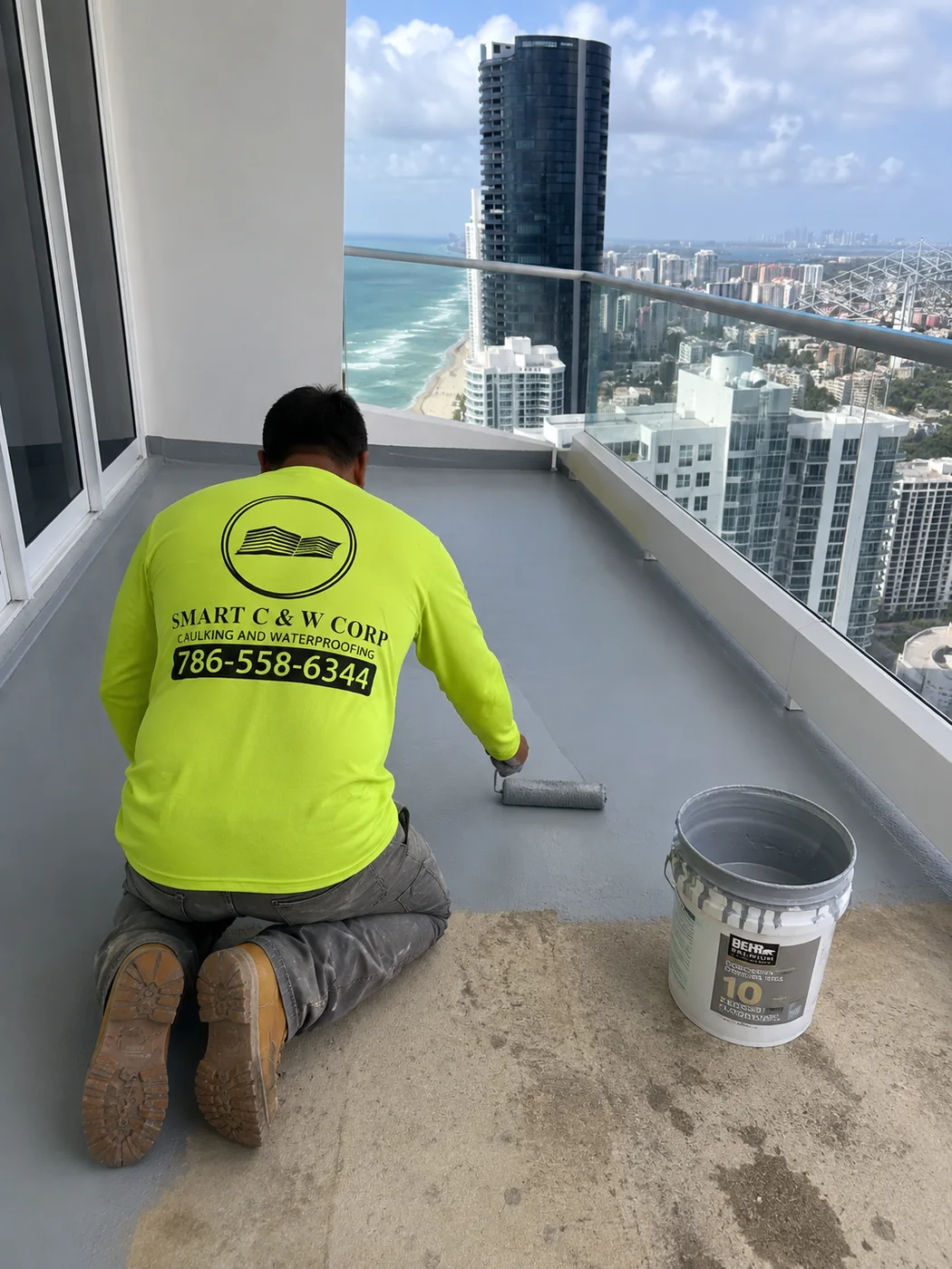 Smart C&W technician applying waterproof coating on a South Florida high-rise balcony